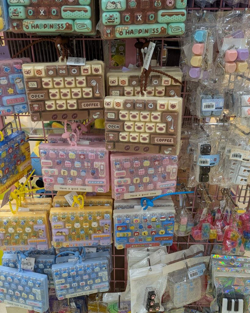 雑貨店に並ぶカラフルなキーボード型ポーチとキー型キーホルダー